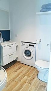 a bathroom with a washing machine and a toilet at La Cabane Urbaine in Brest