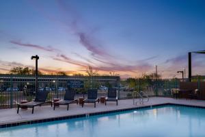 uma piscina com espreguiçadeiras e um pôr-do-sol em WaterWalk Phoenix - North Happy Valley em Phoenix
