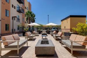 a patio with lounge chairs and tables and umbrellas at WaterWalk Phoenix - North Happy Valley in Phoenix