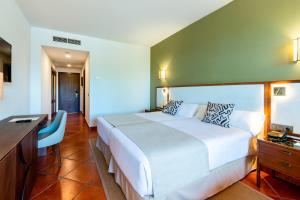 a hotel room with a large bed and a desk at Puerto Antilla Grand Hotel in Islantilla