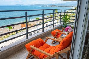 balkon z 2 krzesłami i widokiem na plażę w obiekcie IDEE SUİTES Fethiye w mieście Fethiye