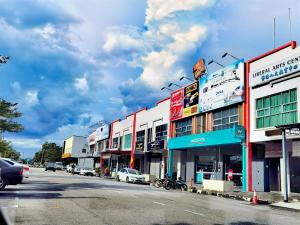 a row of buildings on a city street with cars at 1 Day Car Hotel - BG Perdana in Batu Gajah