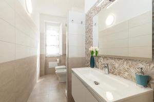 bagno bianco con lavandino e servizi igienici di Appartamento A_Mati a Baunei a Baunei