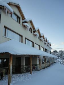 un edificio coperto di neve con sopra della neve di Peninsula de los Coihues a Villa Pehuenia