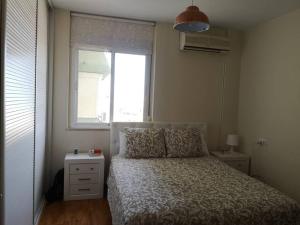 a small bedroom with a bed and a window at XRYHOMES I Residencial en Jerez 4 hab, 2 baños, 7pax, 10 min del centro in Jerez de la Frontera