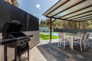a patio with a grill and a table and chairs at Les Roques in Castellnou de Bages