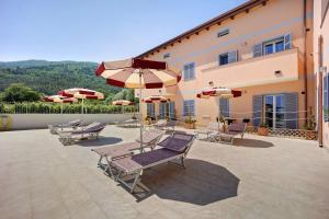 un patio avec des chaises et des parasols en face d'un bâtiment dans l'établissement Antichi Ricordi - Il Pollaio, à Molino Nuovo