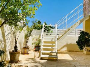 a white staircase with plants on the side of a building at Glamour Luxury Suite Swimming pool in Eilat