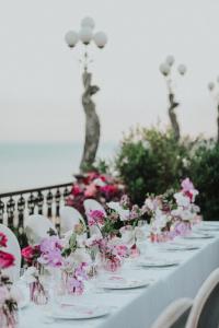 a table with white chairs and pink flowers on it at Grand Hotel Parker's in Naples