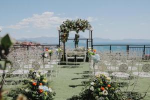 a wedding aisle with chairs and an arch with flowers at Grand Hotel Parker's in Naples