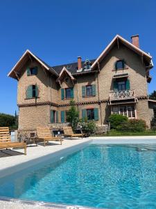 une grande maison avec une piscine en face de celle-ci dans l'établissement O'Cottage double jardin, à Annonay