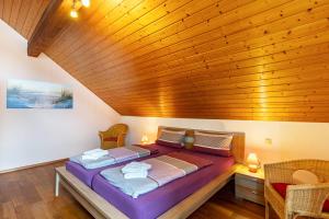 a large bed in a room with a wooden ceiling at Marlene in Friesenheim