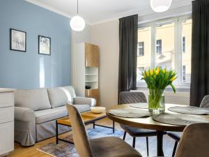 a living room with a table and a couch at Tyzenhauz Apartments Rakowicka Street in Krakow