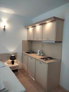 una pequeña cocina con armarios blancos y una cama en Avalon Apartament en Sunny Beach