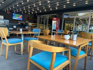 um restaurante com mesas de madeira e cadeiras azuis em Vera Suite Hotel Trabzon em Trebizonda