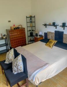 1 Schlafzimmer mit einem großen Bett und 2 Stühlen in der Unterkunft Villa Magnolia in Crosano