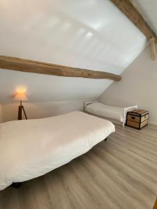 a bedroom with a white bed and a wooden floor at Gîte Les Mariniers - 3 étoiles in Mareuil-sur-Cher