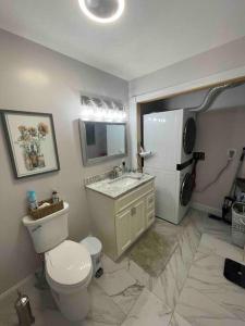 a bathroom with a toilet and a sink and a refrigerator at Beautiful 1 bedroom In the heart of Albany in Albany