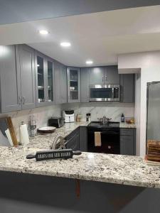 een keuken met grijze kasten en een granieten aanrecht bij Beautiful 1 bedroom In the heart of Albany in Albany