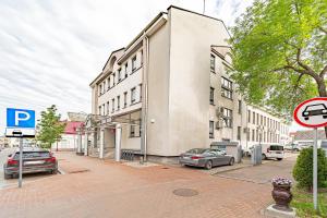 a building on a street with cars parked in front of it at Modern Loft Apartment w/free parking No.2 in Marijampolė