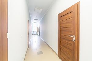 an empty hallway with a wooden door at Modern Loft Apartment w/free parking No.2 in Marijampolė