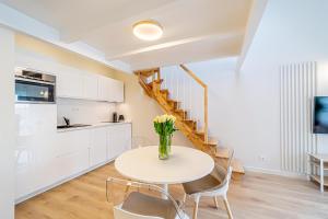 a kitchen and dining room with a table and chairs at Modern Loft Apartment w/free parking No.2 in Marijampolė