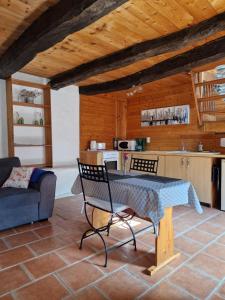 a living room with a table and chairs and a kitchen at Gite rustique en Centre Bretagne in Laniscat +10 photos