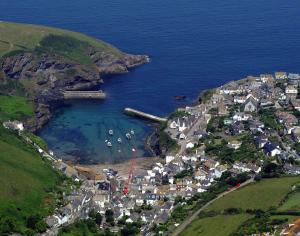 an aerial view of a small town with boats in the water at St Samson in Port Isaac