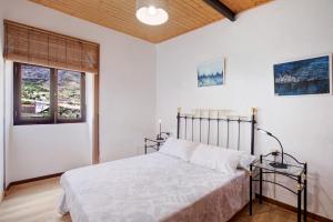 een slaapkamer met een bed en 2 ramen bij Casa La Zahorra in Teno Alto