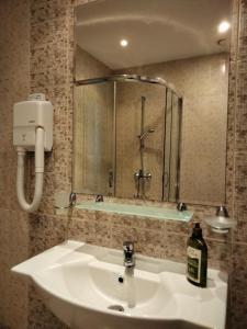 a bathroom with a white sink and a shower at Avalon Apartament in Sunny Beach