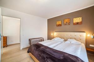 a bedroom with a large bed and three paintings on the wall at Residence Alpina Comfort Nr 1 in Tesimo +15 photos
