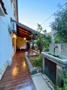 a courtyard of a house with a brick walkway at Apartmani Zora in Cres