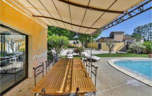 a patio with a table and chairs next to a pool at Nice Home In Lisle Sur La Sorgue With 6 Bedrooms And Outdoor Swimming Pool in L'Isle-sur-la-Sorgue