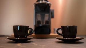 two black coffee cups sitting on a table at Suite de Luxe Jacuzzi balnéo,King size Bed in Collobrières
