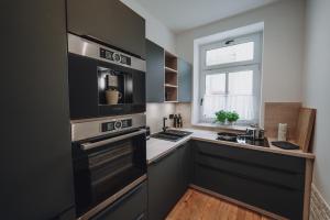 a kitchen with black and white appliances and a window at EDLER WOHNRAUM Luxuriöse 70 qm mit Lift, Einbaukaffeevollautomat, Netflix & Klimaanlage in Chemnitz