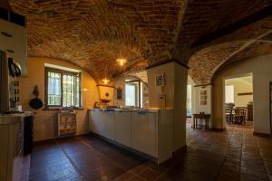a kitchen with a brick ceiling and a counter top at VILLA BOTTERA with Jacuzzi in the garden Cuneo Langhe Piemonte in Riforano