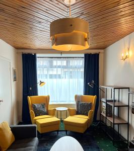 uma sala de estar com cadeiras amarelas, uma mesa e uma janela em Foxy View in Dingle Town! em Dingle
