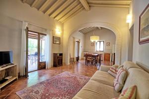 ein Wohnzimmer mit einem Sofa und einem Tisch in der Unterkunft Cuccardino by PosarelliVillas in Bibbona