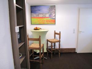 卡塞爾的住宿－Apartment "Hugo37" am Bergpark，一间设有两把椅子的房间和墙上的一幅画