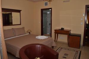 a bedroom with a bed and a table and a mirror at Hotel Tivoli in Tetovo