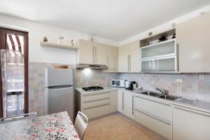 a kitchen with white cabinets and a sink and a refrigerator at Residence San Zeno S P House in Bardolino