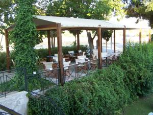 een tuinhuisje met tafels en stoelen in een tuin bij Avaton Hotel in Ligourio