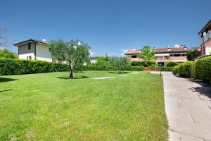 een grasveld met bomen en een stoep bij Residence San Zeno S P House in Bardolino