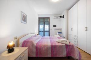biała sypialnia z łóżkiem i lampką na komodzie w obiekcie Residence San Zeno S P House w mieście Bardolino