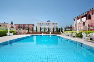 a large swimming pool with white chairs and buildings at Residence San Zeno S P House in Bardolino