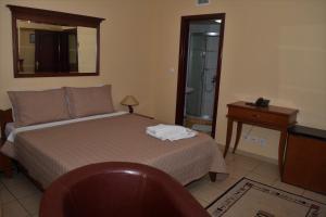 1 dormitorio con cama, mesa y espejo en Hotel Tivoli, en Tetovo