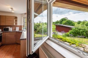 a kitchen with a large window looking out at a yard at Ferienwohnung Alexandra in Rheinfelden