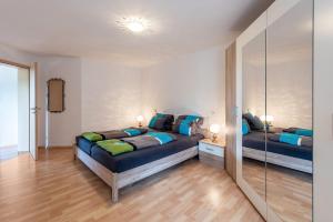a bedroom with two beds and a mirror at Ferienwohnung Alexandra in Rheinfelden
