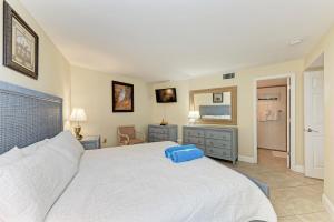 een slaapkamer met een groot wit bed en een spiegel bij Sea Grape Inn 2- BEACHFRONT Property in Longboat Key