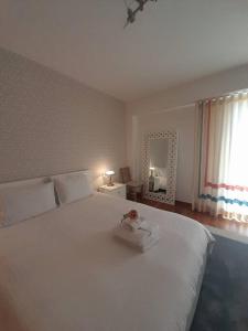 a bedroom with a large white bed and a mirror at Casa da Ria Barra, Free garage in Gafanha da Nazaré